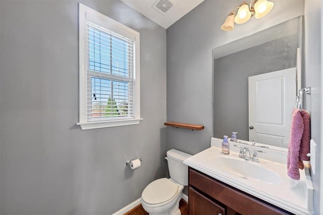 bathroom featuring plenty of natural light, vanity, and toilet