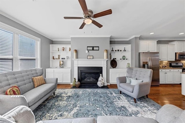 living room featuring dark hardwood / wood-style floors, ceiling fan, and ornamental molding