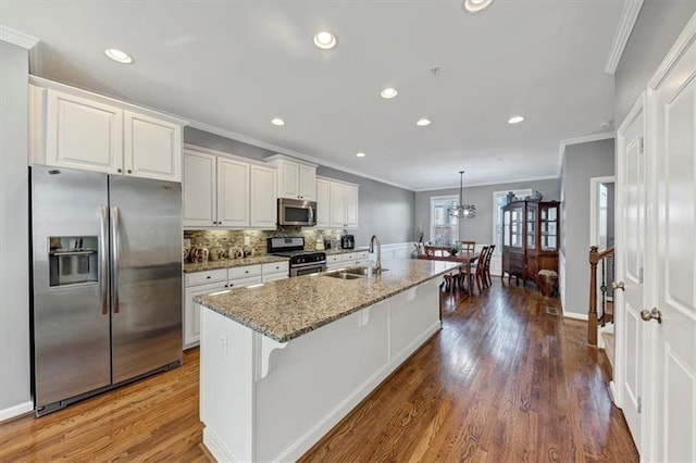 kitchen featuring sink, a kitchen breakfast bar, dark hardwood / wood-style flooring, a center island with sink, and appliances with stainless steel finishes