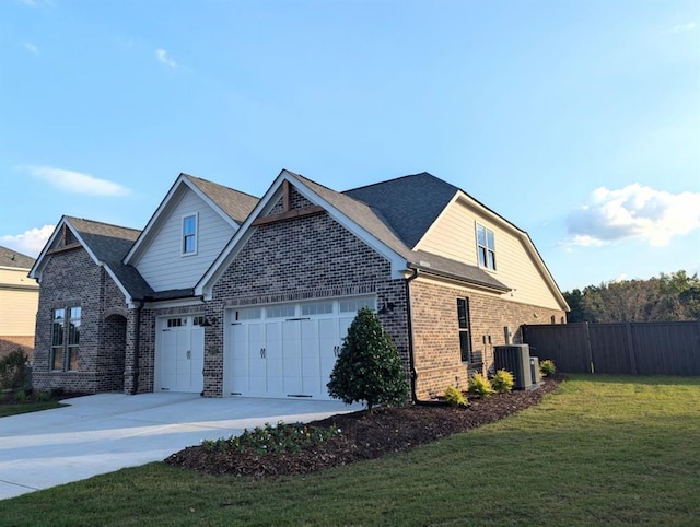 view of front of home with a garage, central air condition unit, and a front yard