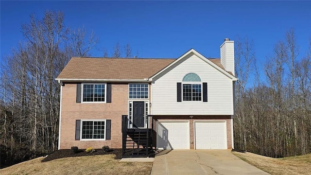 split foyer home with a garage and a front lawn