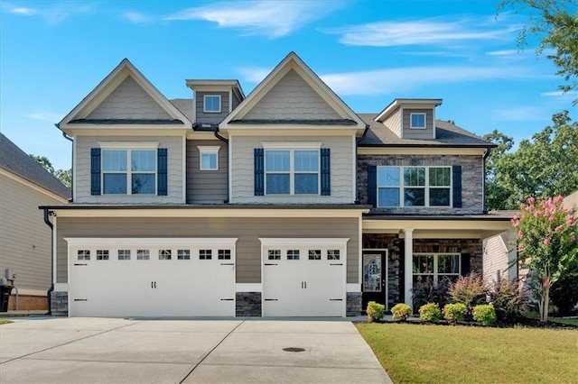 craftsman-style house with an attached garage, stone siding, driveway, and a front lawn