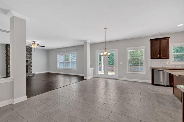 kitchen with dark brown cabinets, a center island, light stone counters, stainless steel appliances, and a sink