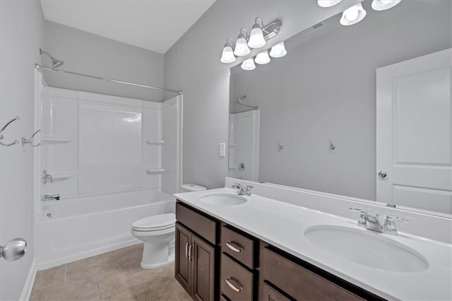 bathroom with toilet, double vanity, a sink, and shower / bathing tub combination