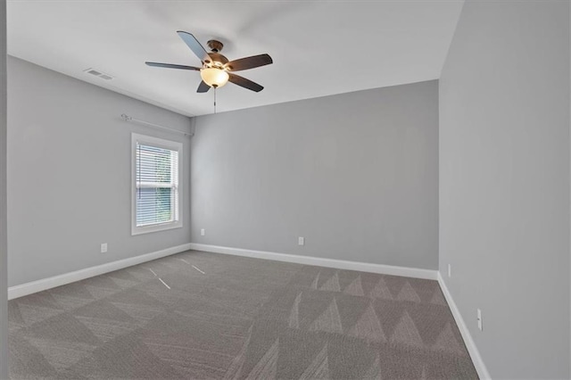 carpeted spare room with visible vents, ceiling fan, and baseboards