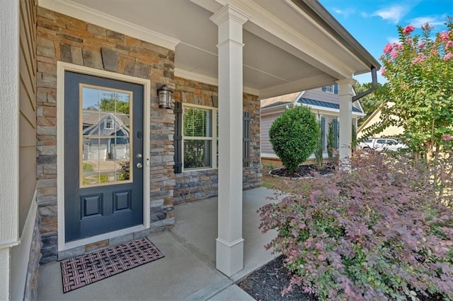 entrance to property featuring stone siding and covered porch