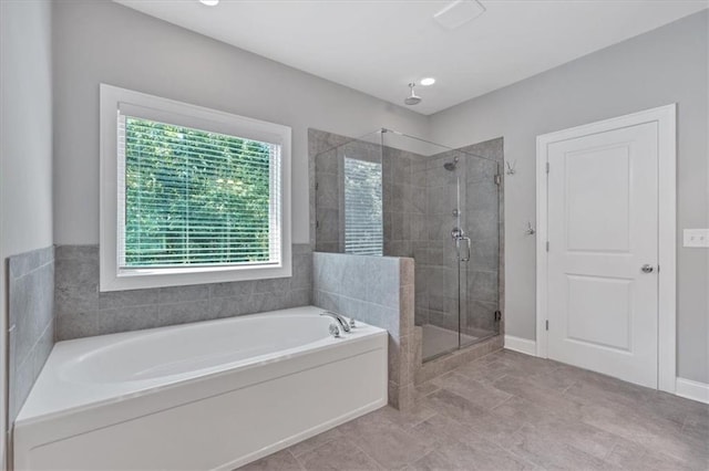 bathroom with baseboards, a garden tub, and a stall shower