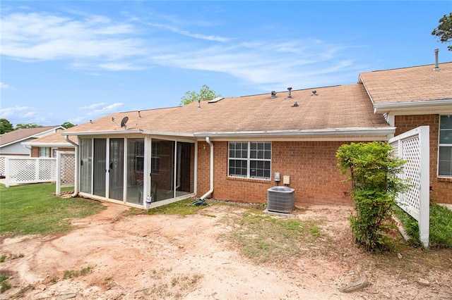 256 Olde Oaks Ln, Riverdale, GA 30274 - rear view of house with a lawn, brick siding, central air condition unit, a sunroom, and a shingled roof
