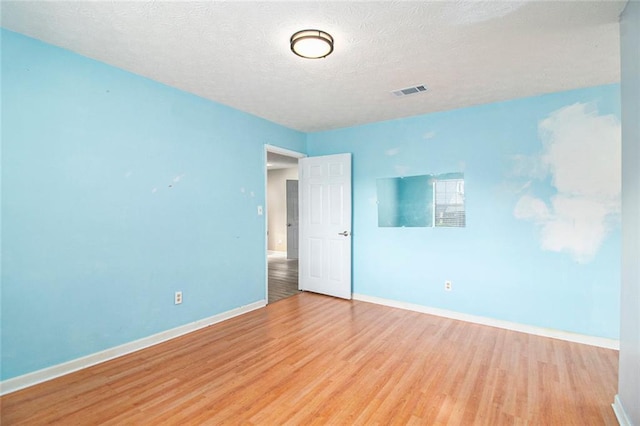 256 Olde Oaks Ln, Riverdale, GA 30274 - unfurnished room featuring a textured ceiling, visible vents, wood finished floors, and baseboards