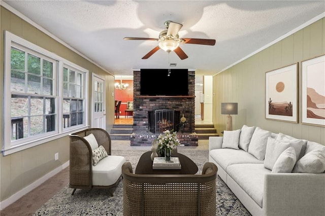 living room with crown molding, ceiling fan, carpet floors, a fireplace, and a textured ceiling