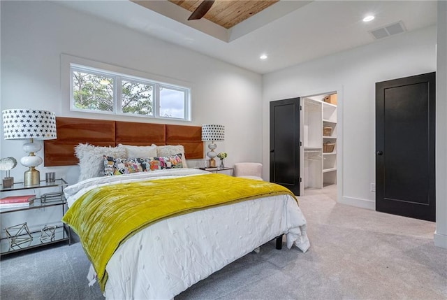 carpeted bedroom with a spacious closet, recessed lighting, visible vents, and baseboards