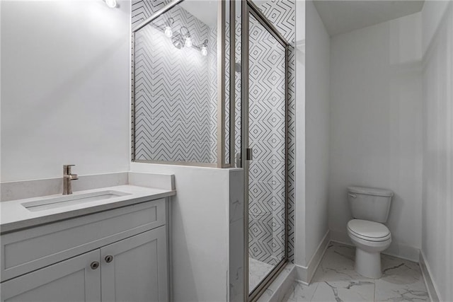 full bathroom featuring vanity, toilet, marble finish floor, a stall shower, and baseboards