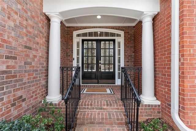 view of exterior entry with brick siding and french doors