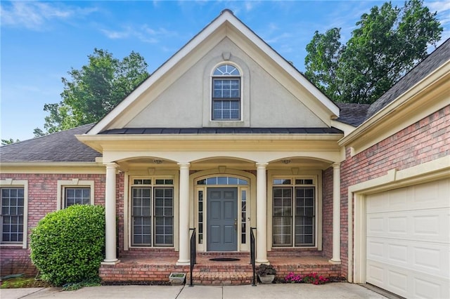 980 Ector Chase NW, Kennesaw, GA 30152 - view of exterior entry featuring brick siding, roof with shingles, an attached garage, stucco siding, and covered porch