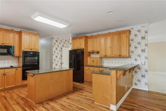 980 Ector Chase NW, Kennesaw, GA 30152 - kitchen with black appliances, wallpapered walls, light wood-style floors, a peninsula, and a breakfast bar