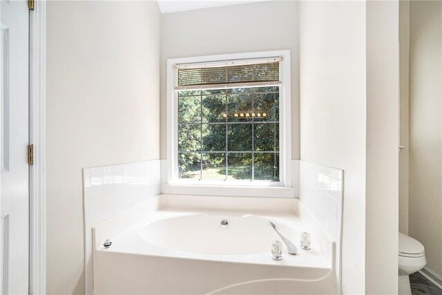 bathroom featuring toilet and a tub