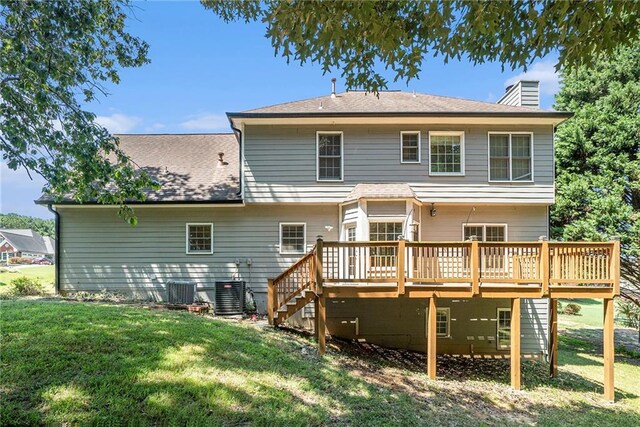 back of property featuring a lawn, a wooden deck, and central AC