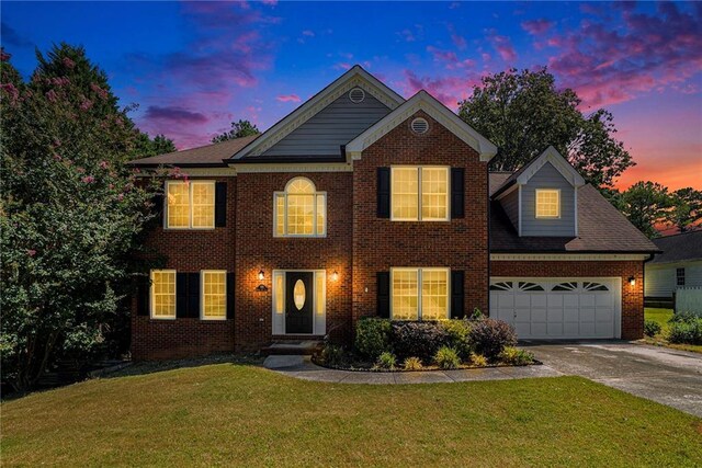 view of front of property featuring a garage and a lawn