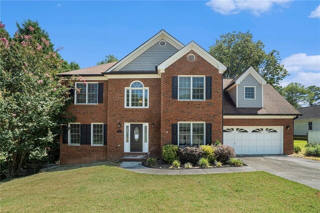 colonial home with a front yard and a garage