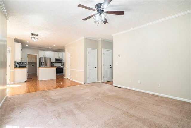 unfurnished living room with ornamental molding, ceiling fan, and light hardwood / wood-style floors