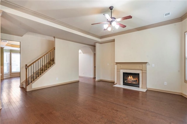 unfurnished living room featuring ceiling fan, wood-type flooring, arched walkways, stairs, and a fireplace with flush hearth