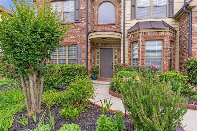 view of exterior entry with brick siding