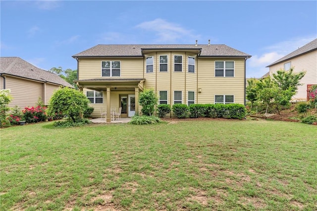 back of house with a yard and a patio