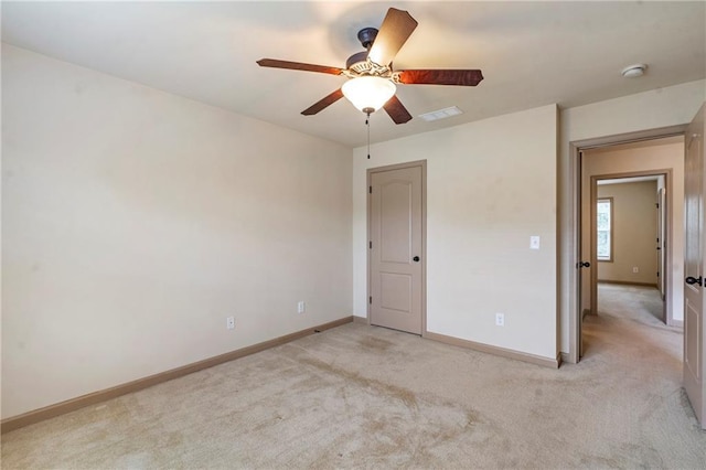 unfurnished bedroom featuring a ceiling fan, baseboards, visible vents, and light carpet