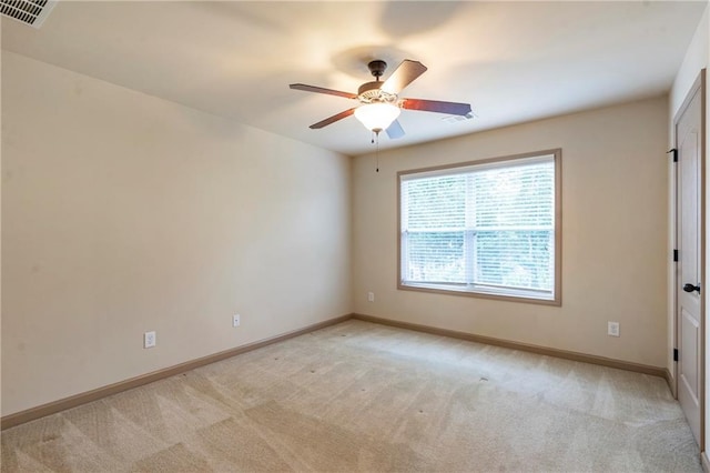 empty room featuring ceiling fan, light carpet, and visible vents