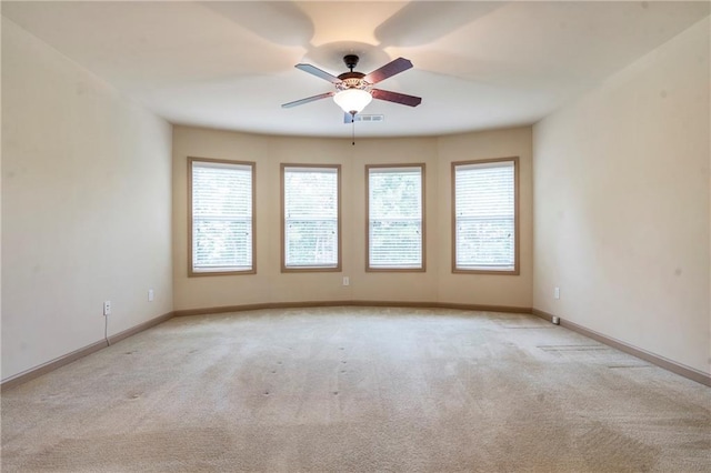 unfurnished room featuring carpet floors, baseboards, ceiling fan, and visible vents