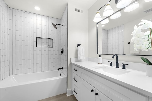 full bathroom with visible vents, vanity, and shower / tub combination