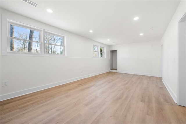 unfurnished room with baseboards, visible vents, light wood-style flooring, and recessed lighting
