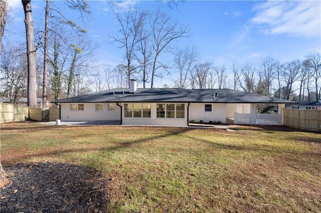 back of house featuring a lawn, stucco siding, fence, and a patio