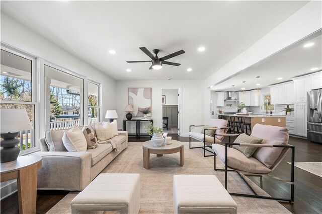 living room featuring wood finished floors, recessed lighting, baseboards, and ceiling fan
