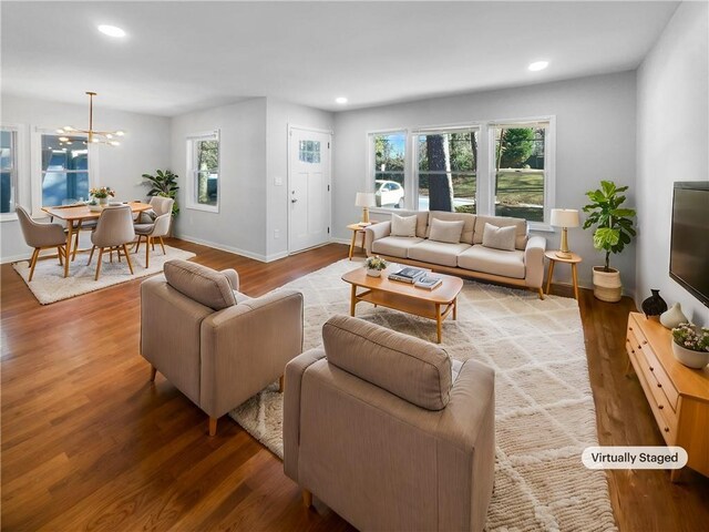 living room with hardwood / wood-style floors and an inviting chandelier