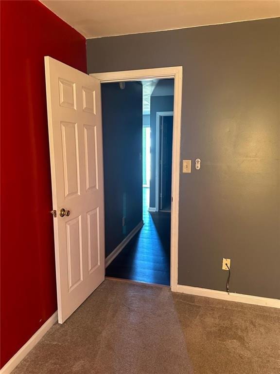 empty room featuring baseboards and carpet floors