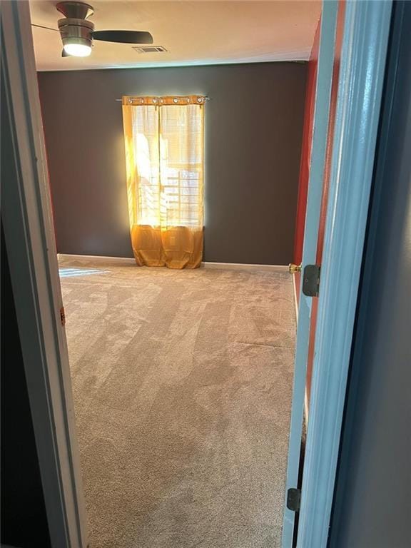 empty room featuring visible vents, baseboards, ceiling fan, and carpet flooring