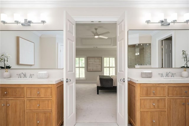 full bathroom featuring a ceiling fan, ornamental molding, two vanities, a sink, and ensuite bath