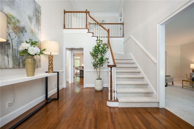 entrance foyer featuring stairway, baseboards, ornamental molding, and wood finished floors