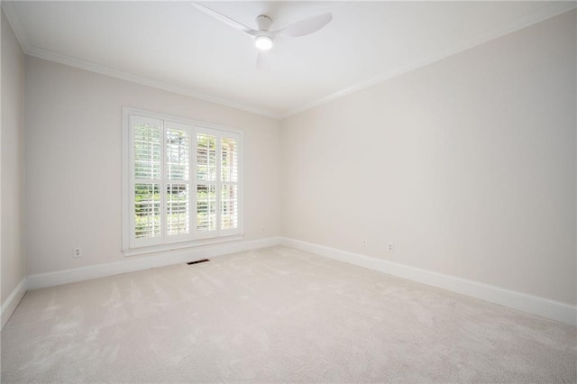 spare room featuring crown molding, a ceiling fan, baseboards, and light colored carpet
