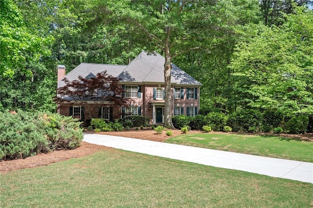 view of front facade featuring a chimney and a front yard