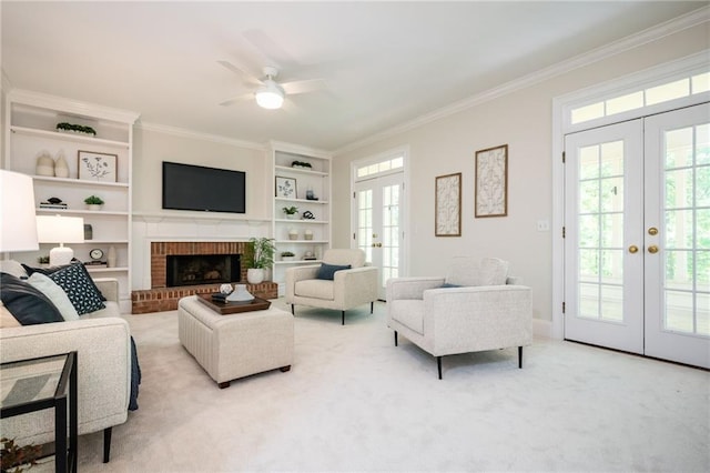 living area with french doors, built in features, crown molding, and a healthy amount of sunlight
