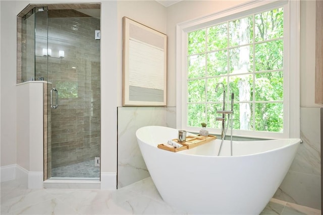 full bath featuring a healthy amount of sunlight, a stall shower, and marble finish floor