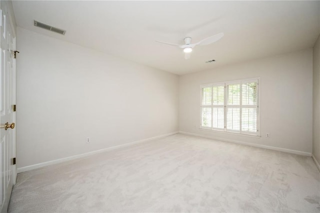 empty room featuring visible vents, a ceiling fan, baseboards, and light carpet