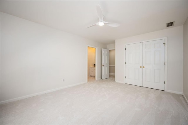 unfurnished bedroom featuring baseboards, light carpet, a closet, and visible vents