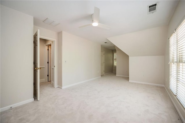 additional living space featuring a wealth of natural light, ceiling fan, light carpet, and visible vents