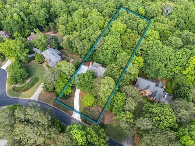 bird's eye view with a wooded view