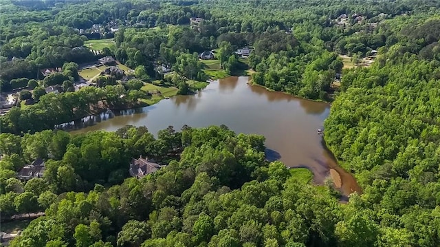birds eye view of property with a water view and a wooded view