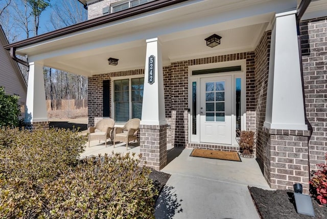 entrance to property with covered porch and brick siding