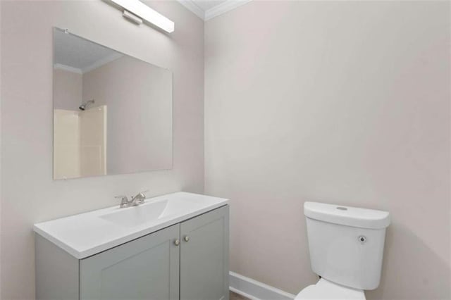 full bath featuring ornamental molding, toilet, vanity, baseboards, and a shower